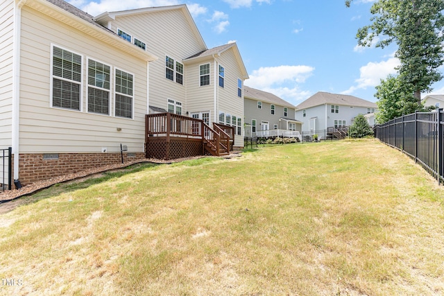 rear view of house featuring a deck and a lawn