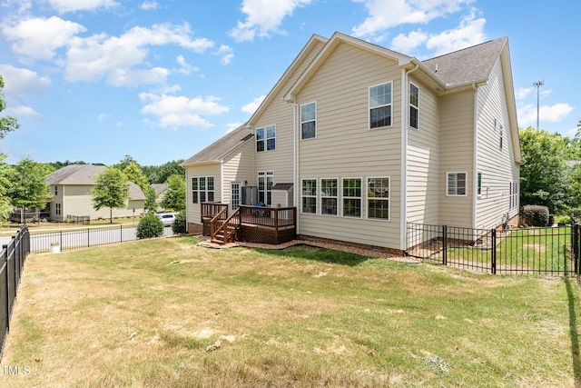 rear view of house featuring a wooden deck and a yard