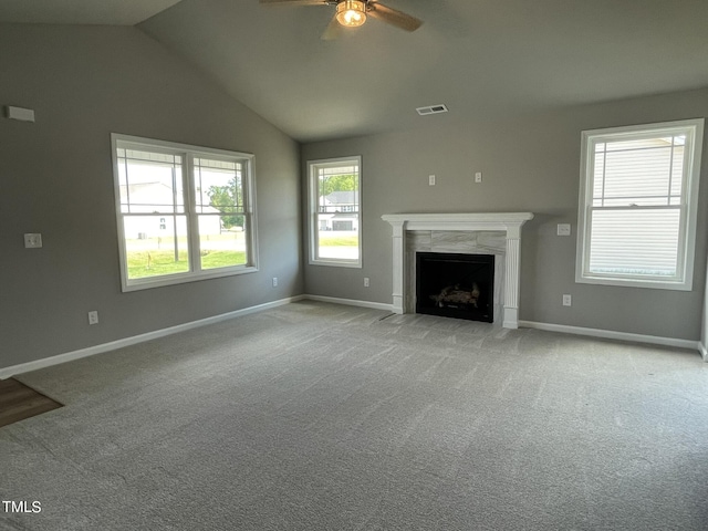 unfurnished living room with visible vents, baseboards, a fireplace, ceiling fan, and light carpet