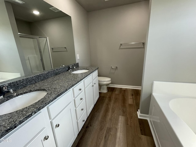 full bath with a sink, a stall shower, a garden tub, and wood finished floors
