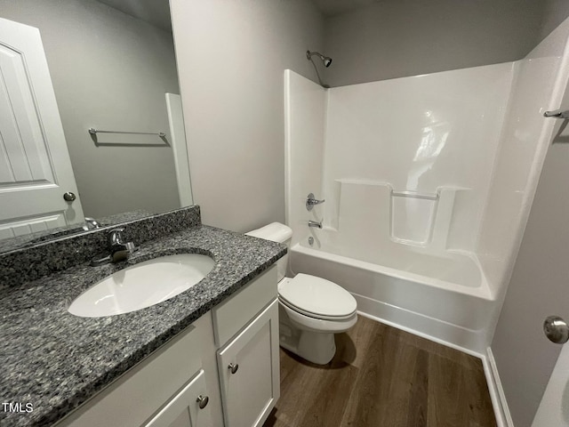 full bath featuring toilet, wood finished floors, bathtub / shower combination, and vanity