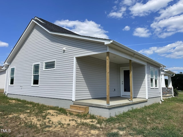 back of property featuring covered porch