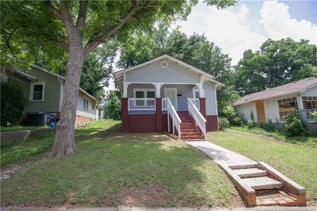 bungalow featuring central AC unit, a porch, and a front lawn