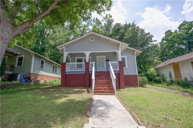 bungalow-style house featuring covered porch and a front lawn