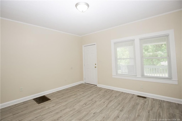 unfurnished room featuring crown molding, visible vents, and light wood finished floors