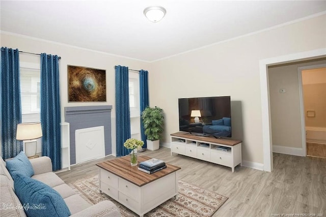 living area with light wood-type flooring, crown molding, and baseboards