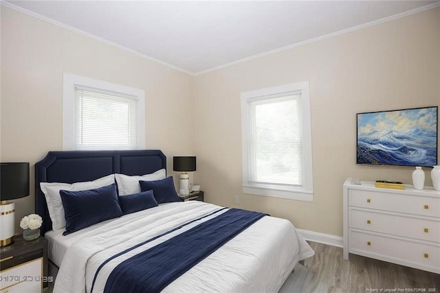 bedroom featuring crown molding, baseboards, and wood finished floors