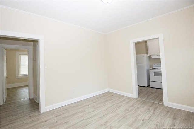 unfurnished room with crown molding, baseboards, and light wood-type flooring