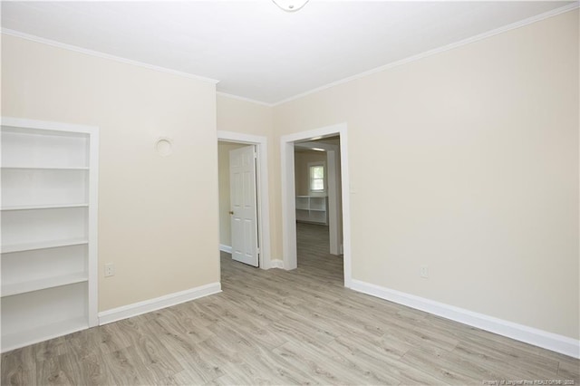 spare room with crown molding, baseboards, and wood finished floors