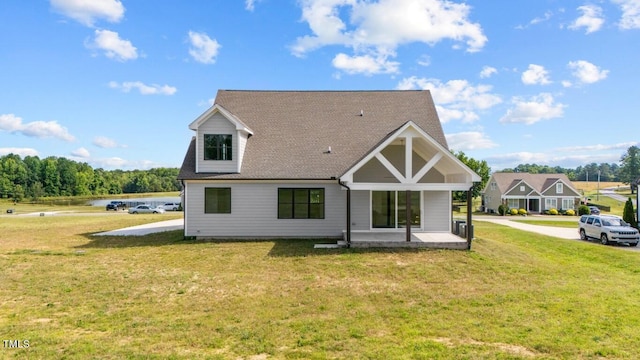 rear view of house featuring a yard and a patio