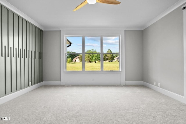 empty room with crown molding, light colored carpet, and ceiling fan