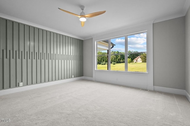 carpeted empty room featuring crown molding, a healthy amount of sunlight, and ceiling fan