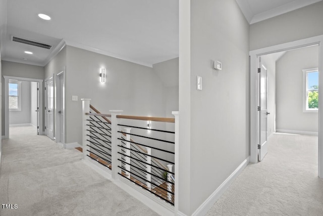 hall featuring ornamental molding and light colored carpet