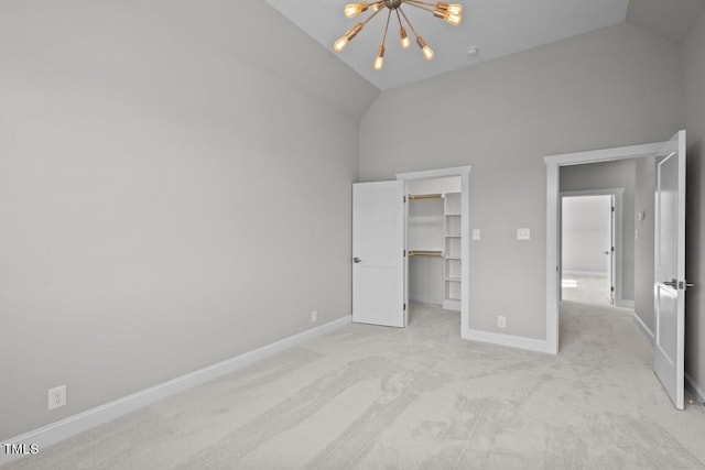 unfurnished bedroom featuring a spacious closet, a chandelier, high vaulted ceiling, a closet, and light colored carpet