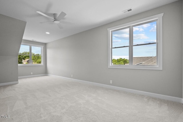 carpeted spare room featuring ceiling fan