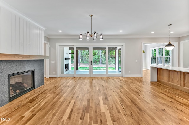 unfurnished living room featuring a tile fireplace, crown molding, and plenty of natural light