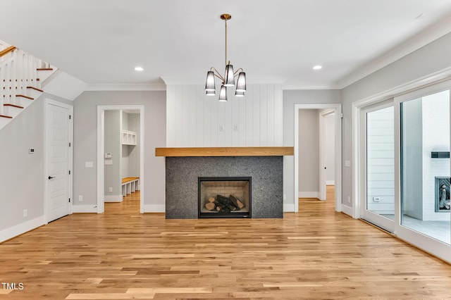 unfurnished living room featuring light wood-type flooring, crown molding, and a chandelier