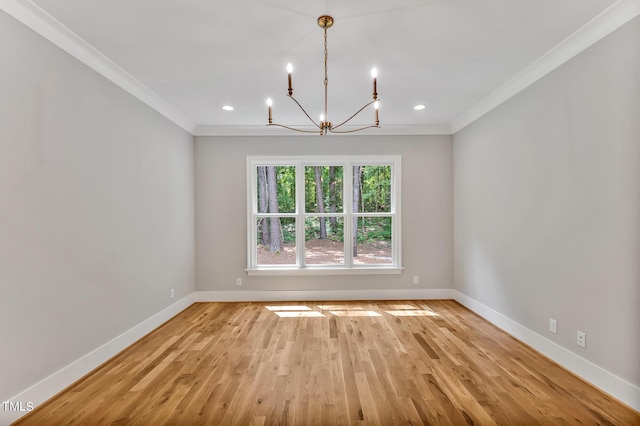 unfurnished room featuring crown molding, light wood-type flooring, and an inviting chandelier