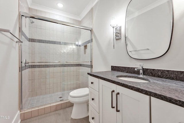 bathroom with vanity, toilet, a shower with door, and ornamental molding