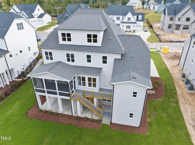 back of property with a sunroom and a deck