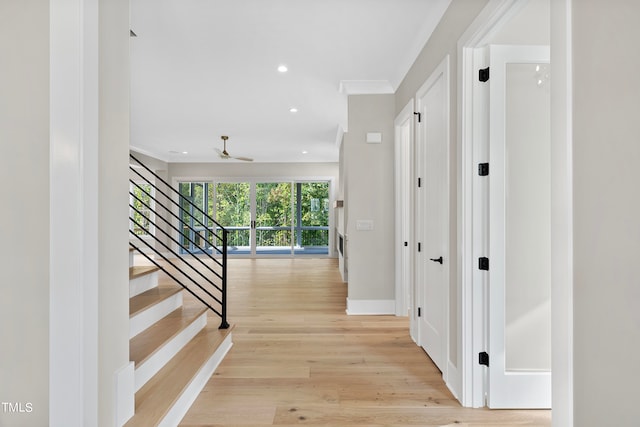 hall with crown molding and light wood-type flooring