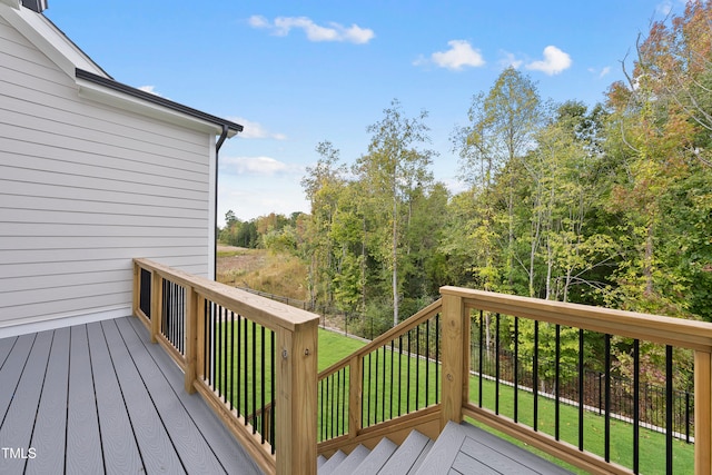 wooden terrace featuring a lawn