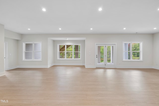 unfurnished living room featuring french doors and light wood-type flooring