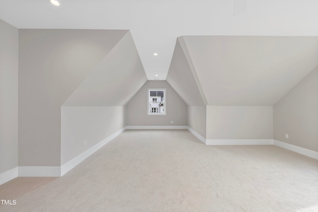 bonus room with vaulted ceiling and light carpet