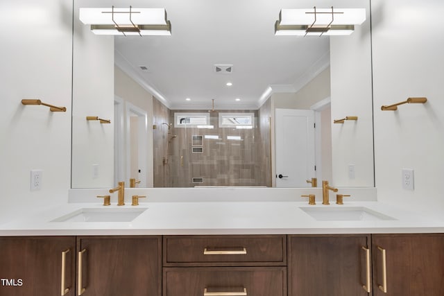 bathroom with crown molding, tiled shower, and vanity