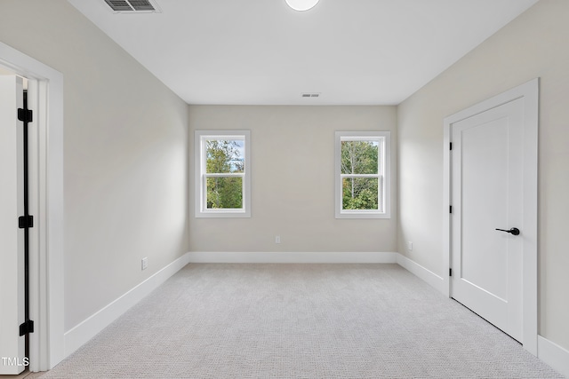 empty room with a healthy amount of sunlight and light colored carpet