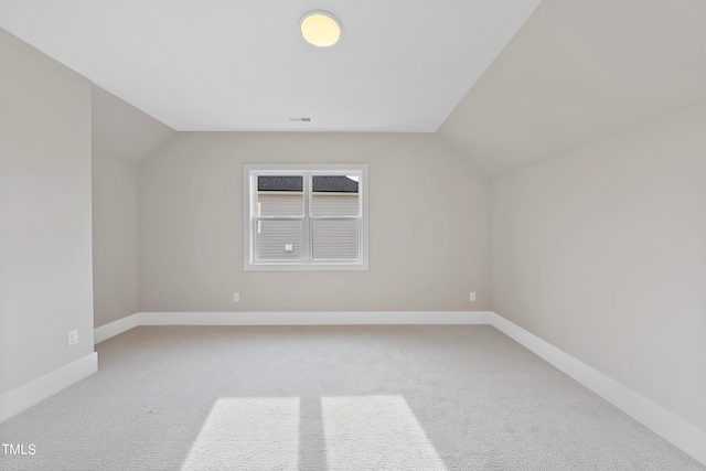 additional living space with vaulted ceiling and carpet