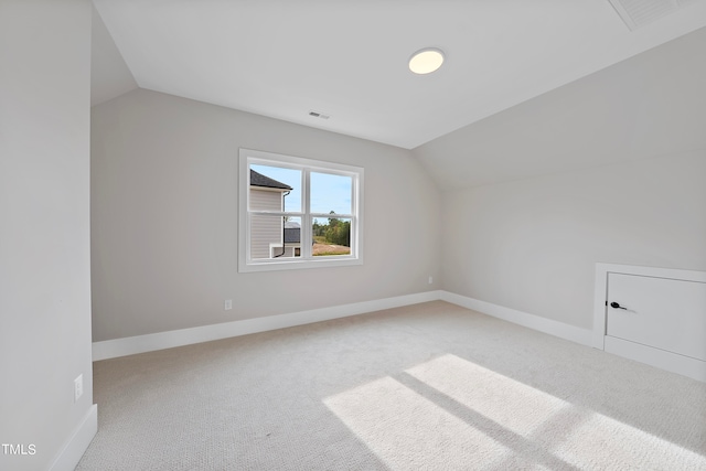 additional living space with lofted ceiling and light carpet