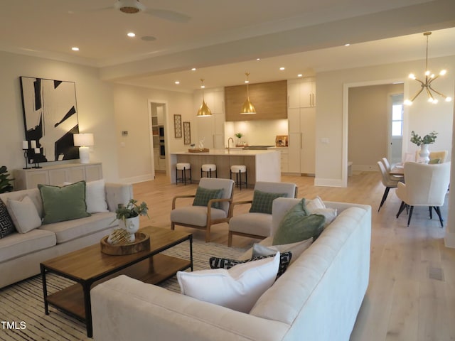 living room with an inviting chandelier and light hardwood / wood-style flooring