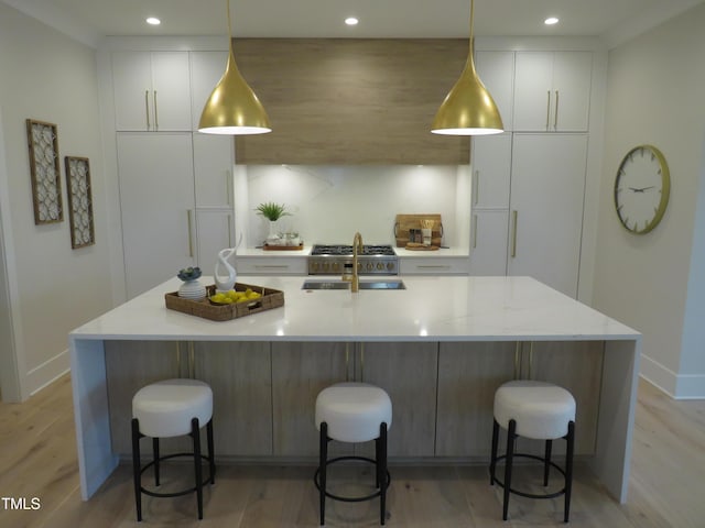 kitchen with hanging light fixtures, sink, a breakfast bar, and a spacious island