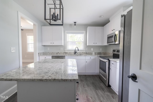 kitchen with white cabinetry, appliances with stainless steel finishes, and a kitchen island