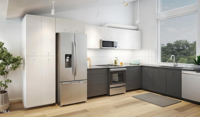 kitchen with light wood-type flooring, gray cabinetry, stainless steel appliances, sink, and white cabinetry