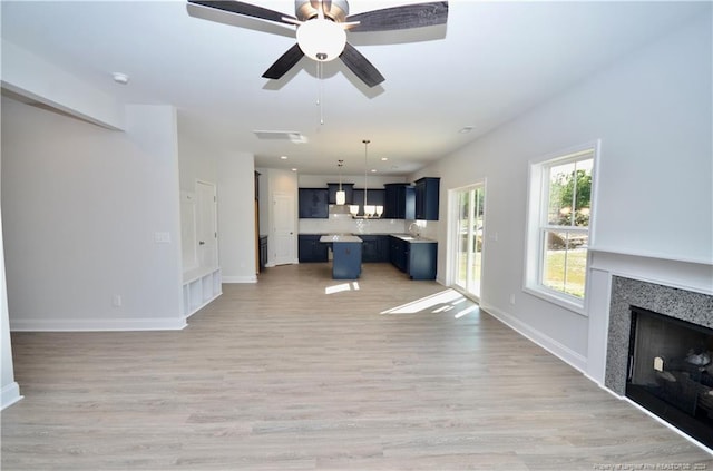 unfurnished living room with ceiling fan and light wood-type flooring