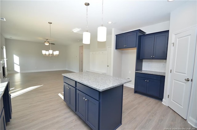 kitchen featuring tasteful backsplash, ceiling fan, blue cabinetry, and a kitchen island