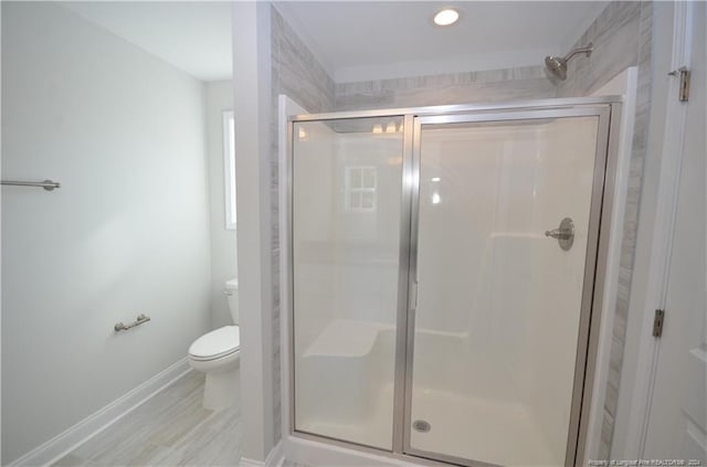 bathroom with toilet and a shower with shower door