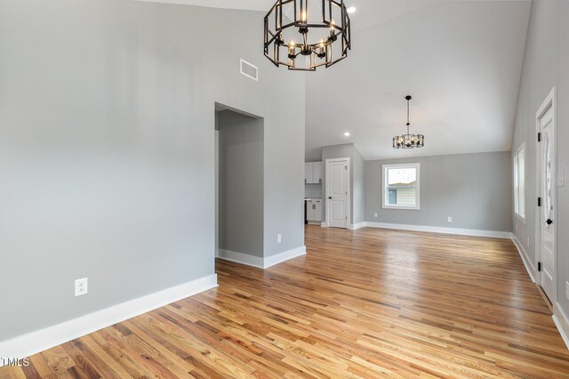 interior space with an inviting chandelier, light hardwood / wood-style flooring, and high vaulted ceiling