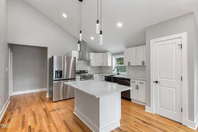 kitchen featuring wall chimney exhaust hood, stainless steel appliances, a center island, and white cabinets