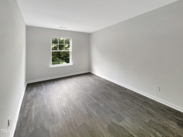 spare room with dark wood-type flooring