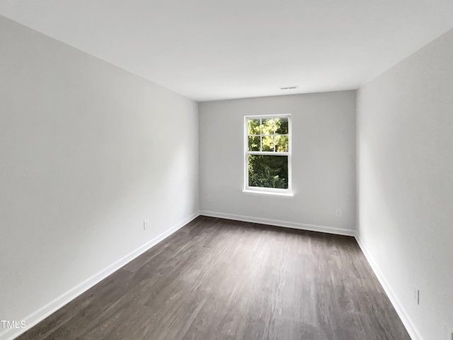 empty room with dark hardwood / wood-style flooring