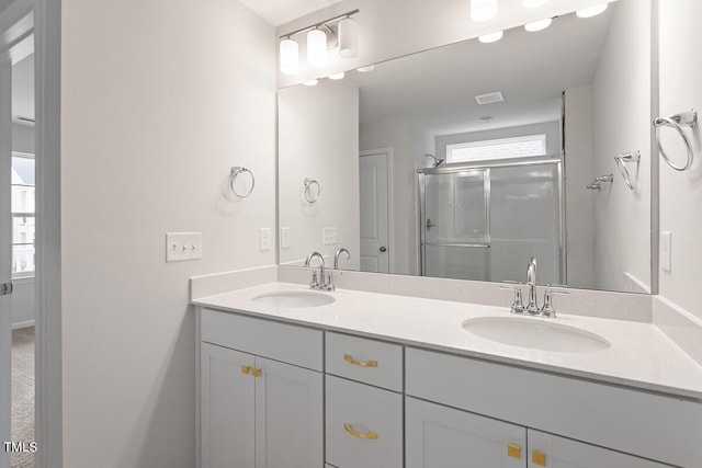 bathroom featuring vanity, a shower with door, and a healthy amount of sunlight