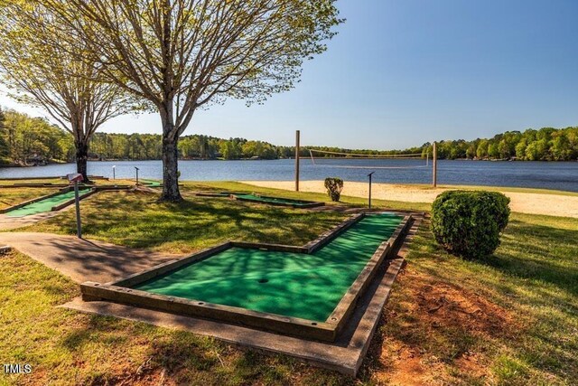 view of property's community with a lawn, a water view, and volleyball court