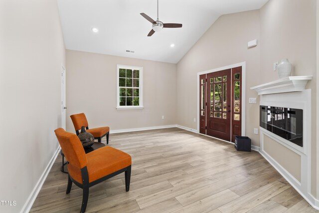 sitting room with light hardwood / wood-style flooring, ceiling fan, and high vaulted ceiling