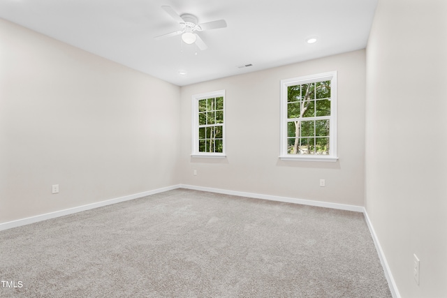 empty room featuring ceiling fan and carpet