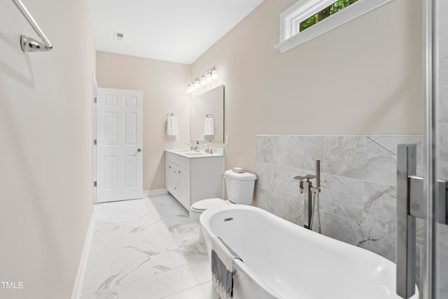 bathroom with a bath, vanity, and toilet