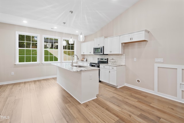 kitchen featuring pendant lighting, a kitchen island with sink, sink, white cabinetry, and appliances with stainless steel finishes