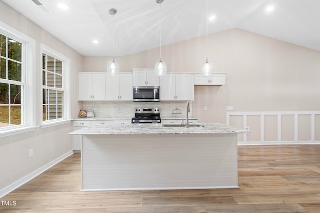 kitchen featuring sink, white cabinetry, vaulted ceiling, light hardwood / wood-style flooring, and appliances with stainless steel finishes